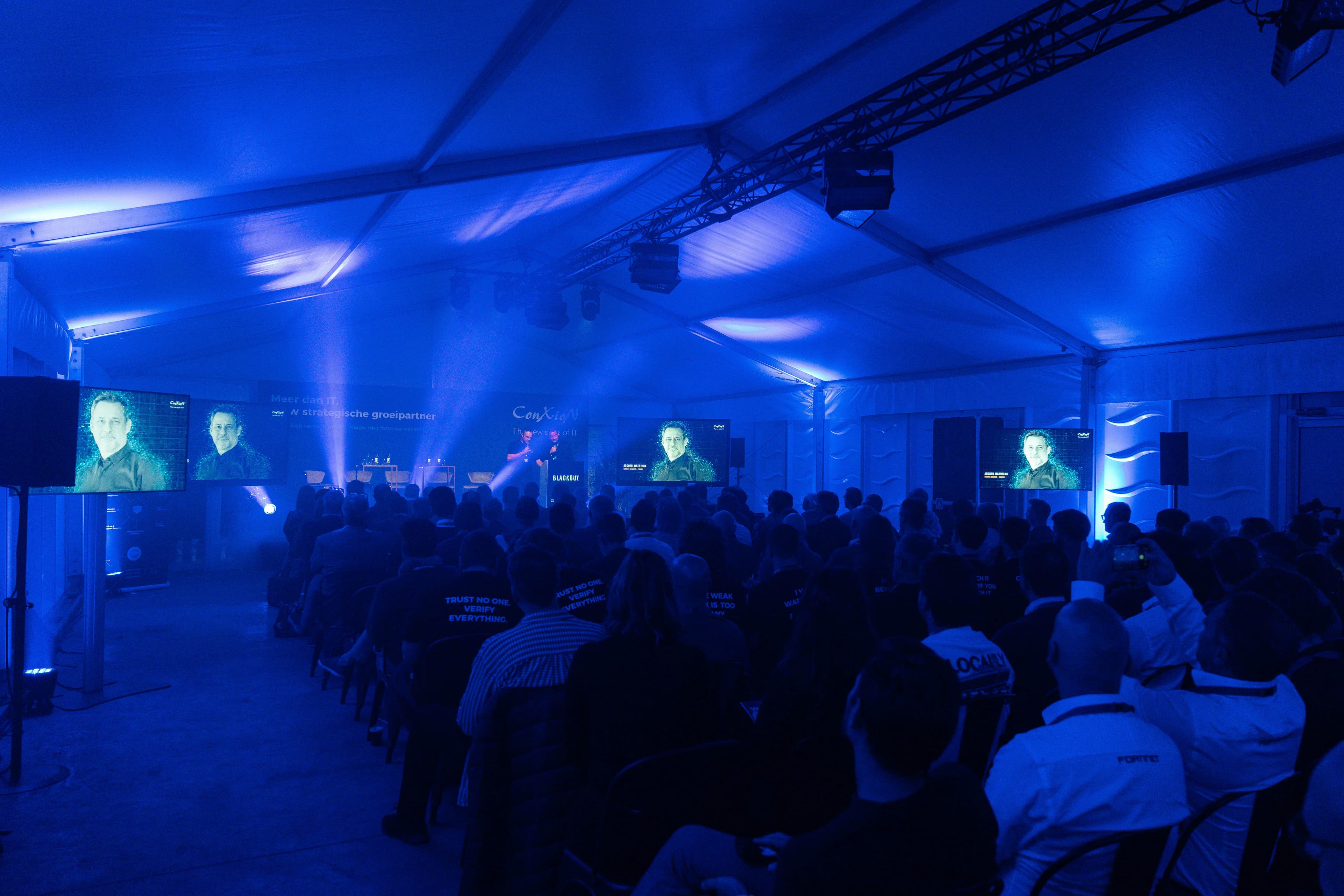 Gasten tijdens presentatie in blauwe zaal - ConXion Security Day