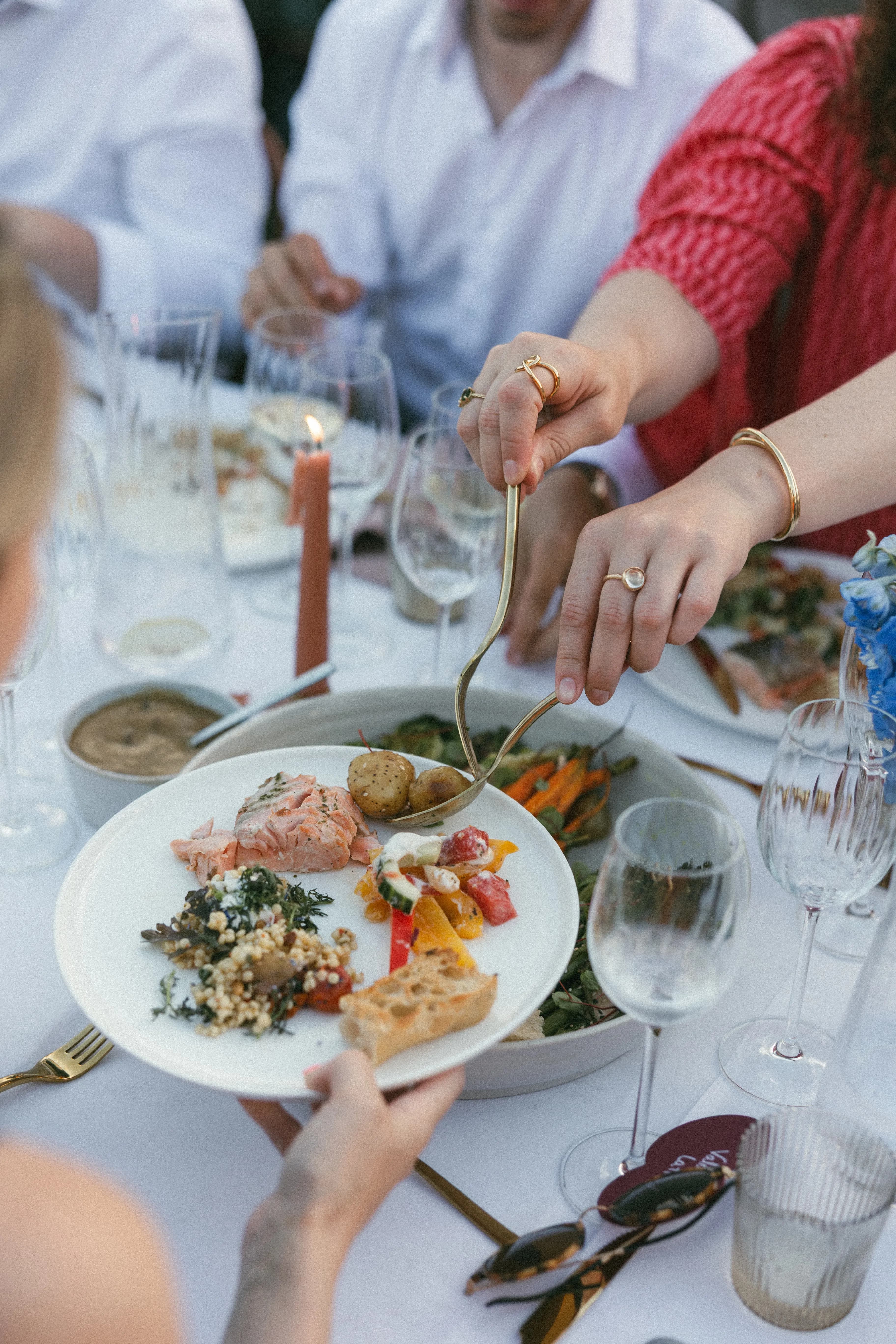 Gasten scheppen zalm en groenten op - trouw catering menu
