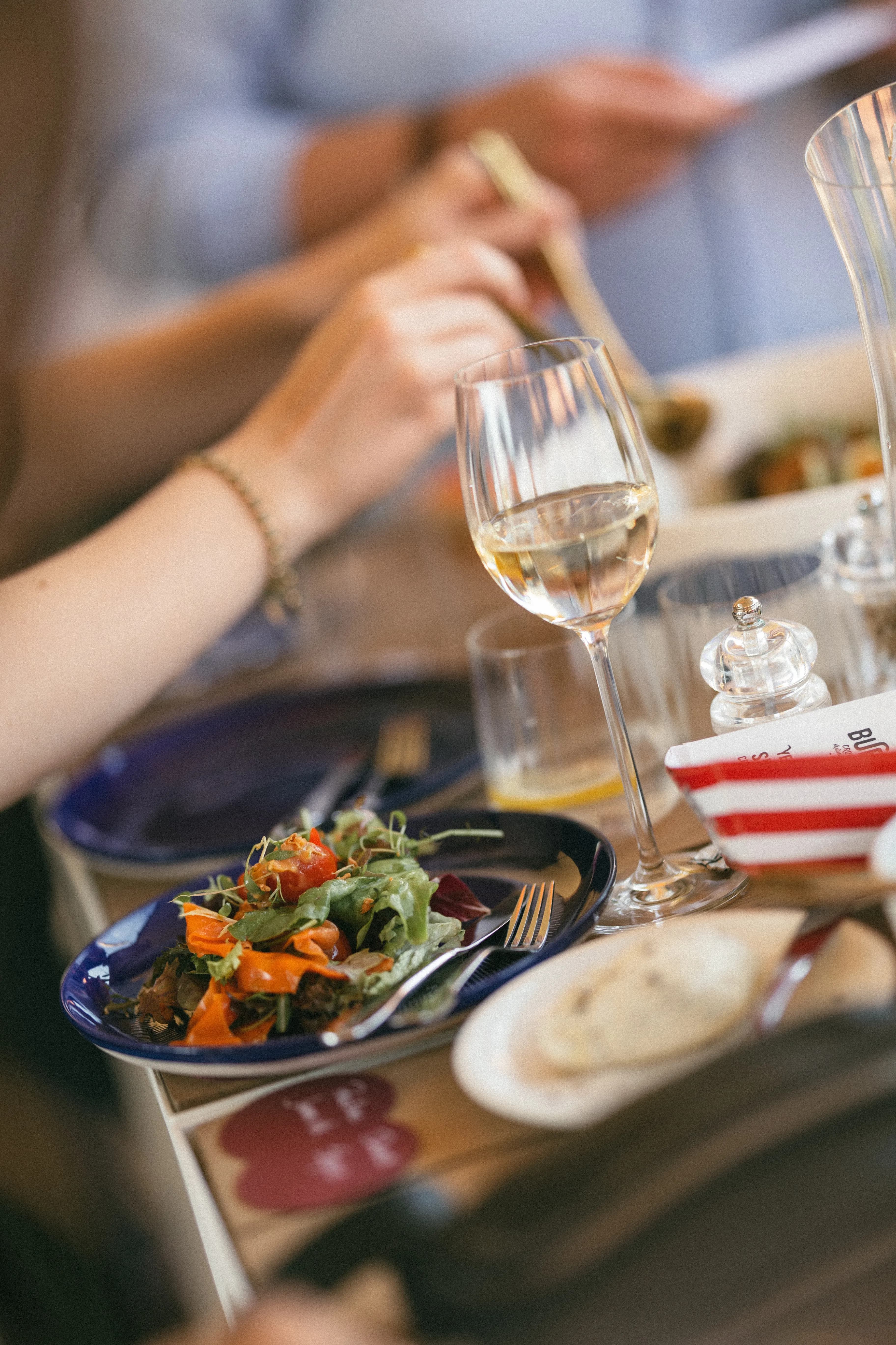 Salade en witte wijn aan feesttafel - trouwfeest catering